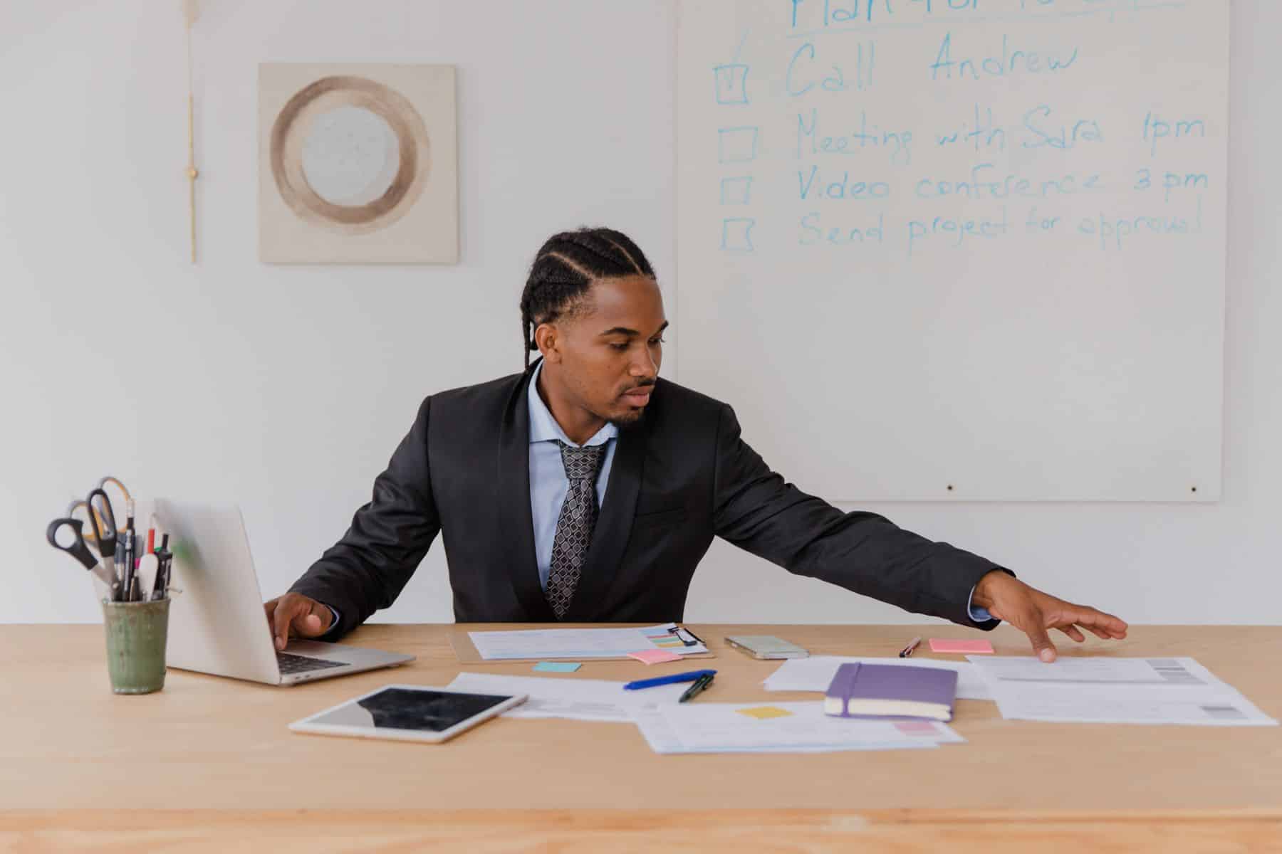 Professional organizing meeting notes and action items at a desk